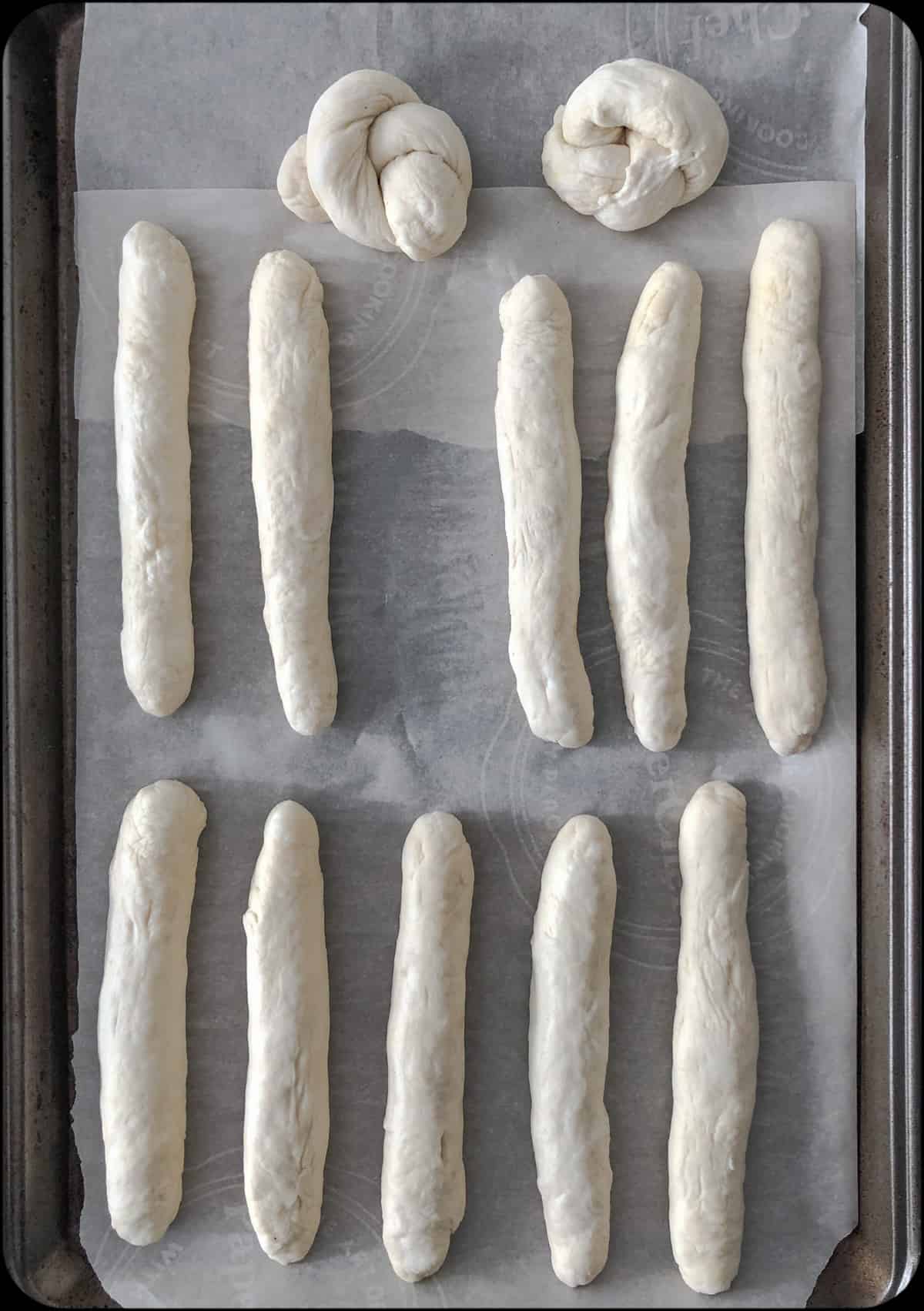Baking sheet of hand rolled breadsticks.