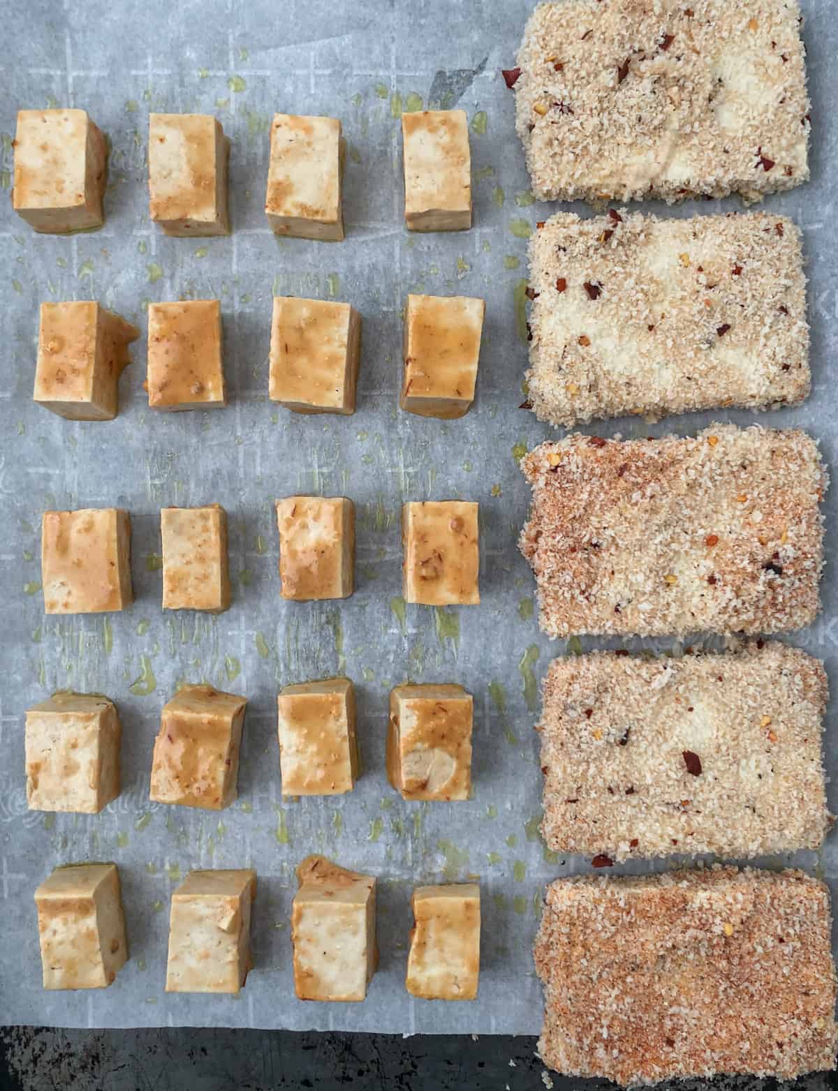 Tofu cubes and slabs on a baking sheet.