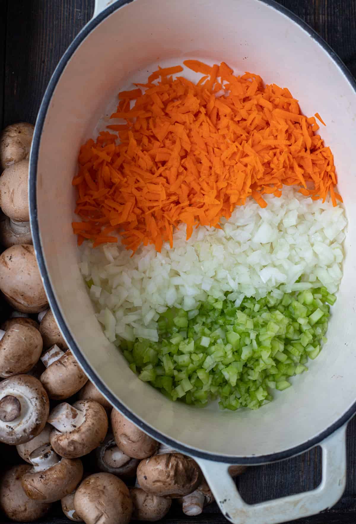 Diced carrots, onions, celery and mushrooms in a Dutch oven.