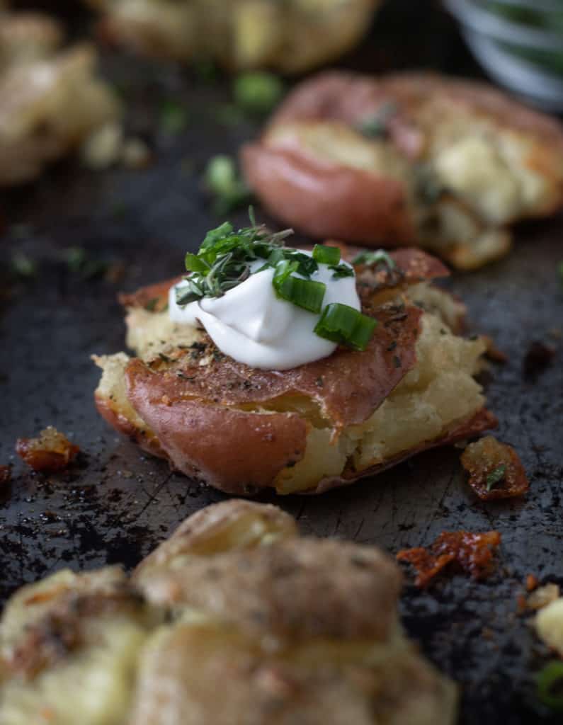 Crispy smashed potatoes topped with sour cream and green onions.