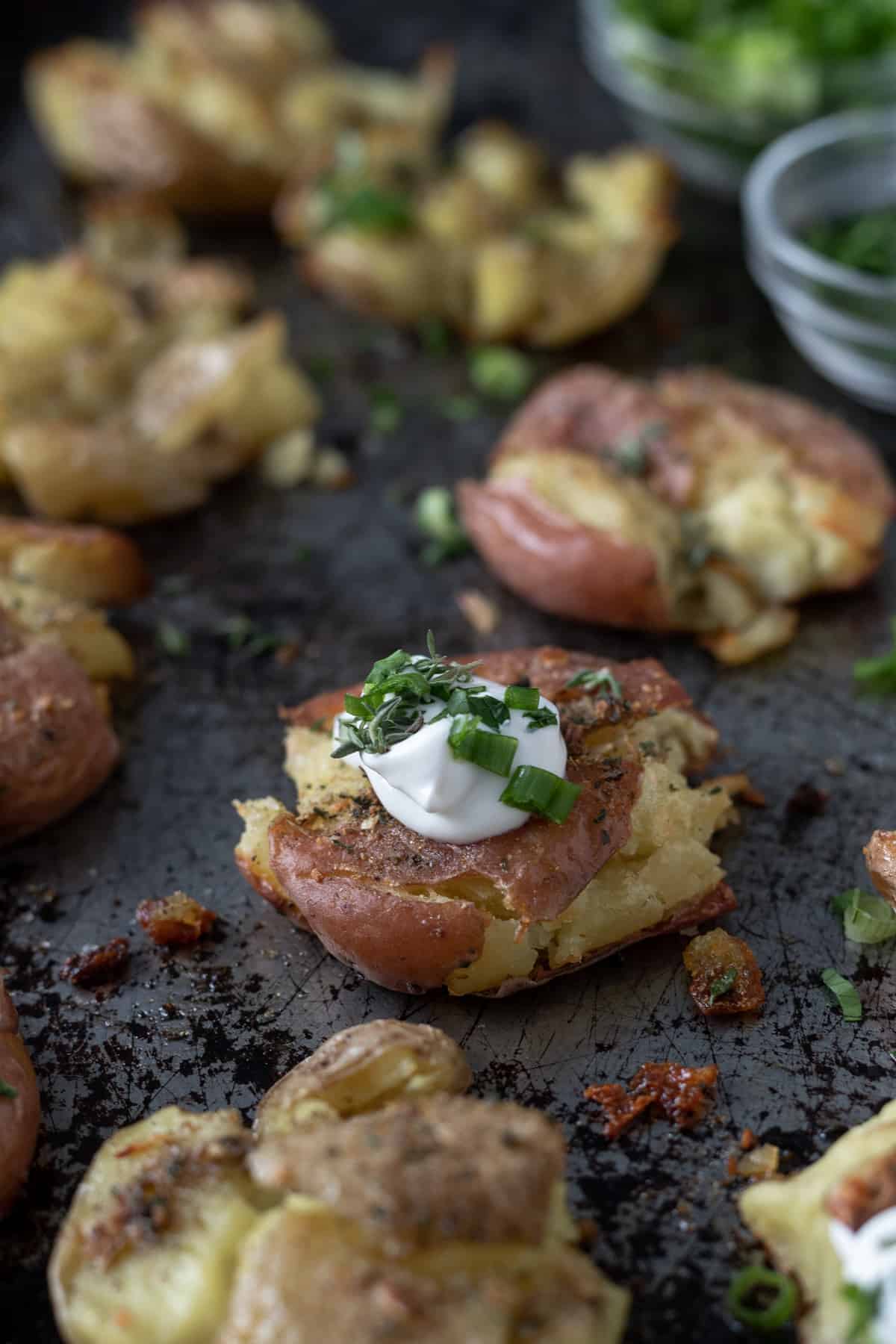 Crispy smashed potatoes topped with sour cream and green onions.