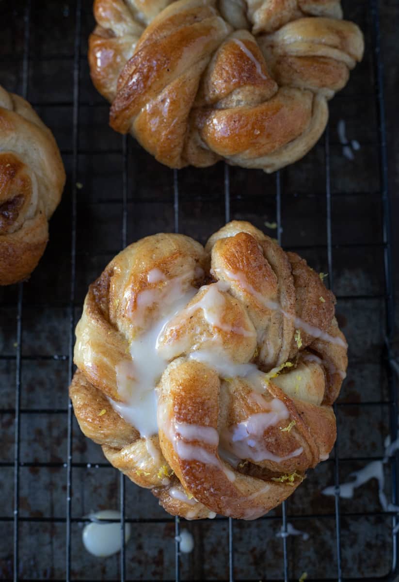 Swedish cardamom bun with icing cooling on a baking rack.