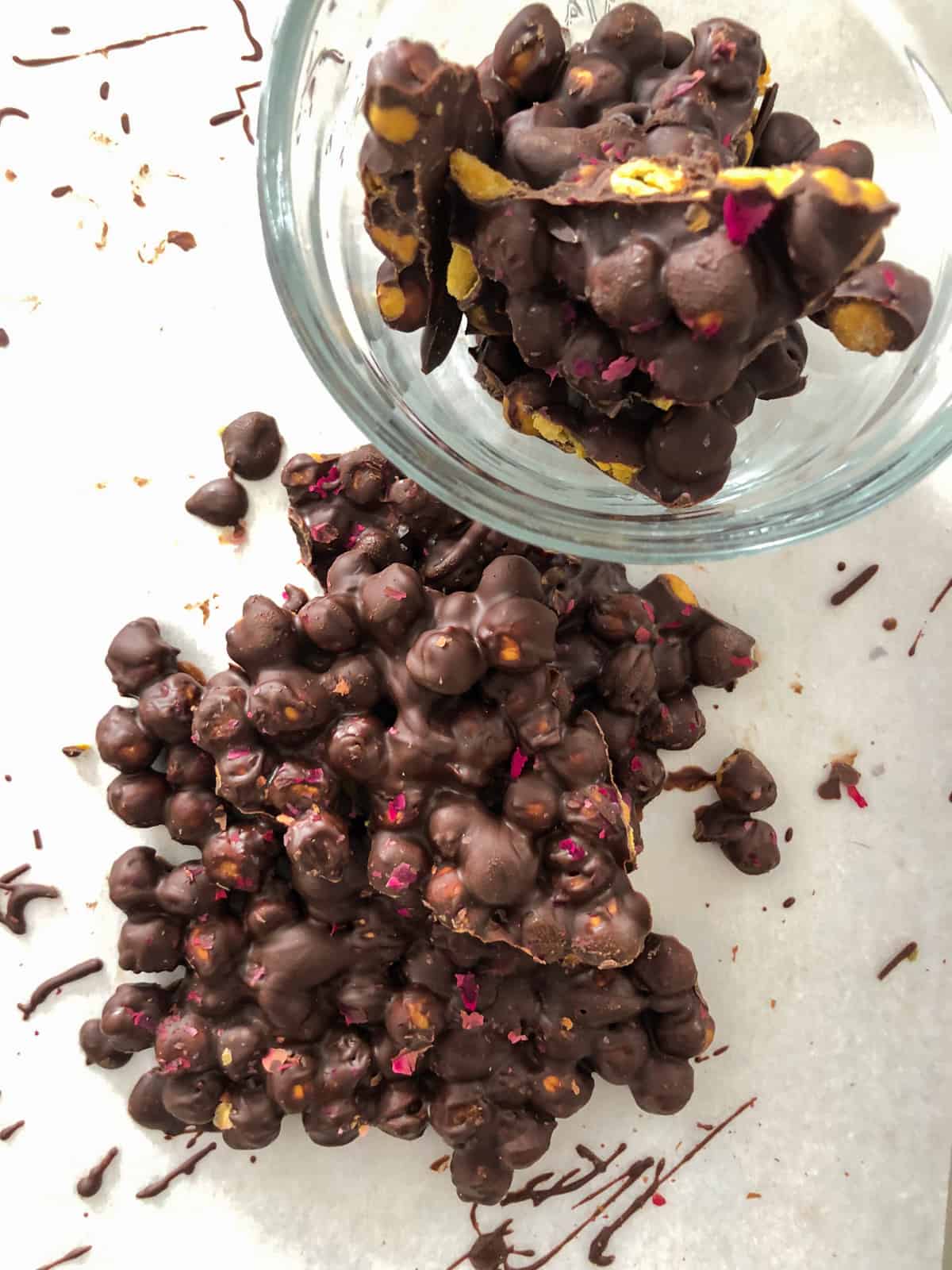 Chocolate chickpea bark piled in bowl on baking sheet.