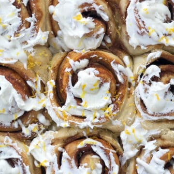Close up of cinnamon rolls slathered in frosting.