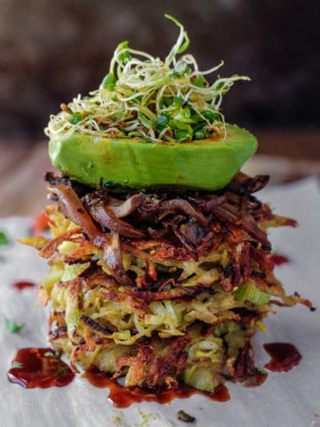Potato Leek Pancake stack with spicy mushrooms and an avocado boat on top