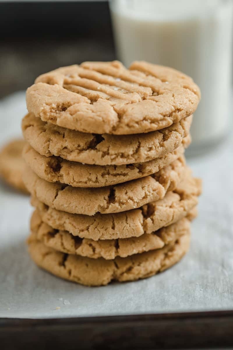 Stack of peanut butter cookies and plant based milk.