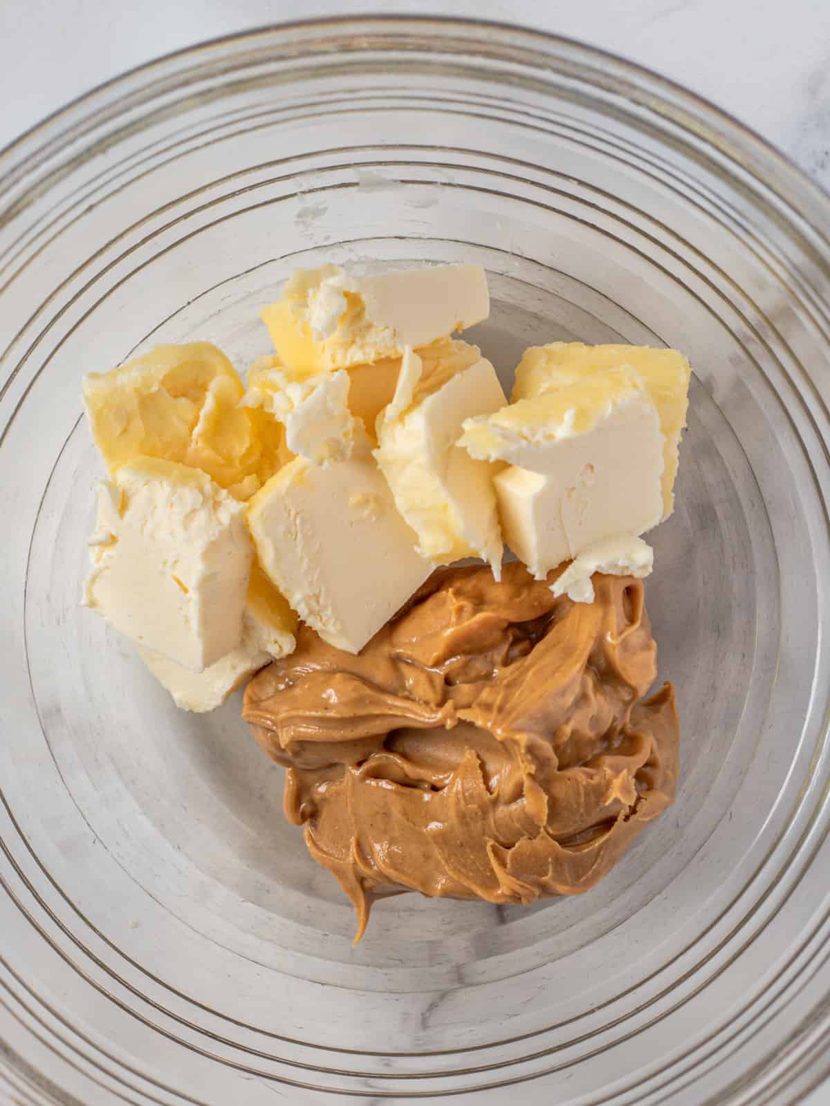 Butter and peanut butter in a mixing bowl.