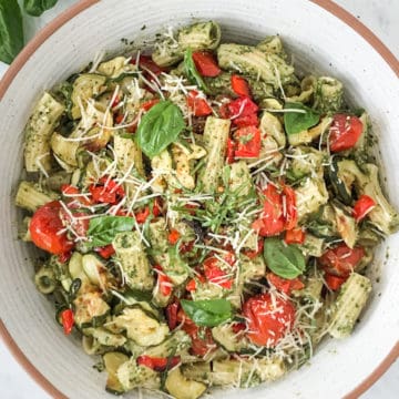 Pesto pasta with vegetables tossed with pasta in a bowl.