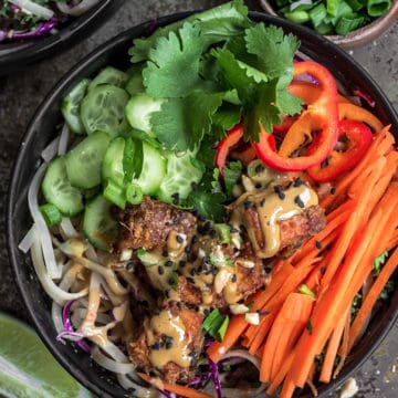 Satay tofu noodle bowl with carrots cucumbers and mint..