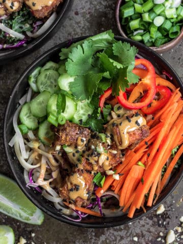 Satay tofu noodle bowl with carrots cucumbers and mint..