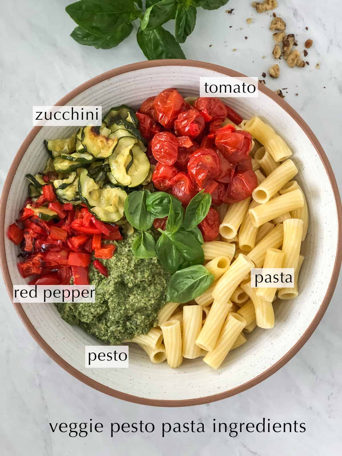 Veggie pesto pasta ingredients in a large mixing bowl.