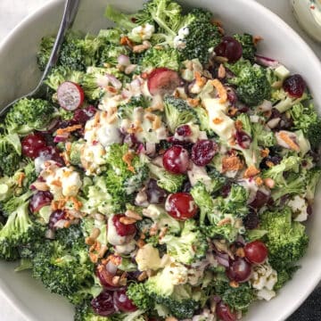 Bowlful of broccoli salad with grapes sunflower seeds and cranberries.