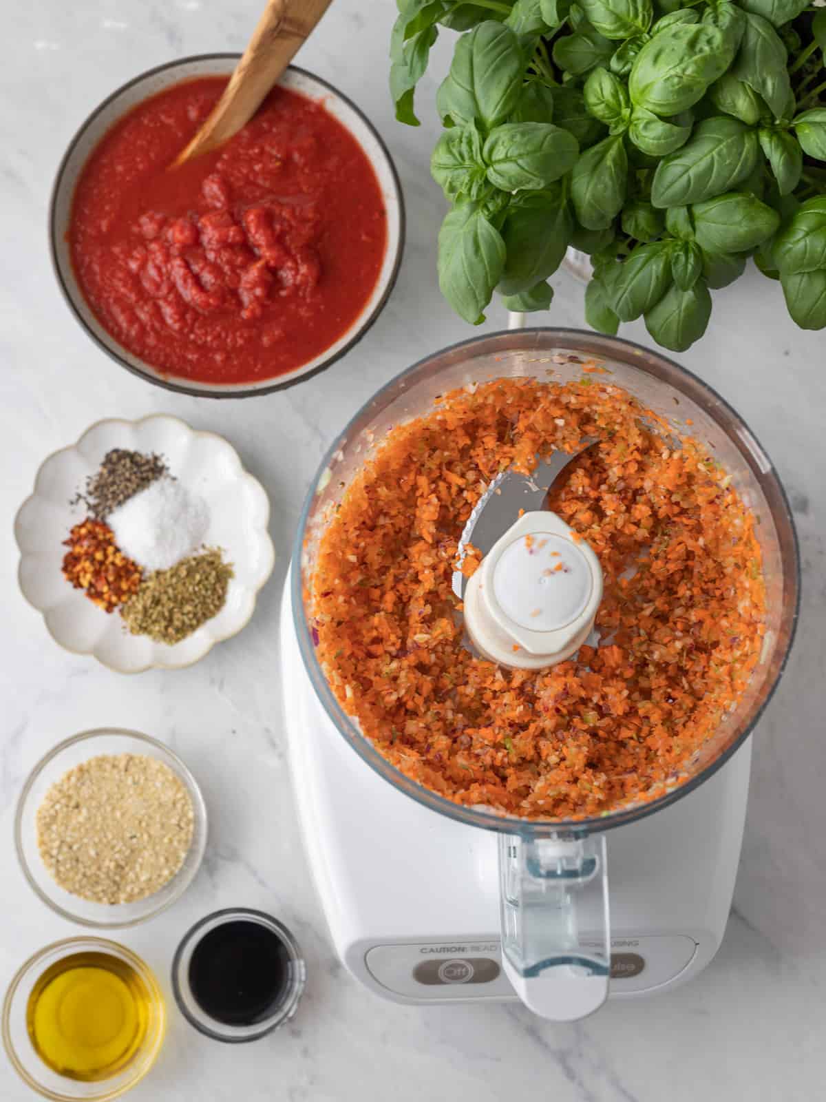 Ingredients for tofu pasta in food processor and around it in bowls.