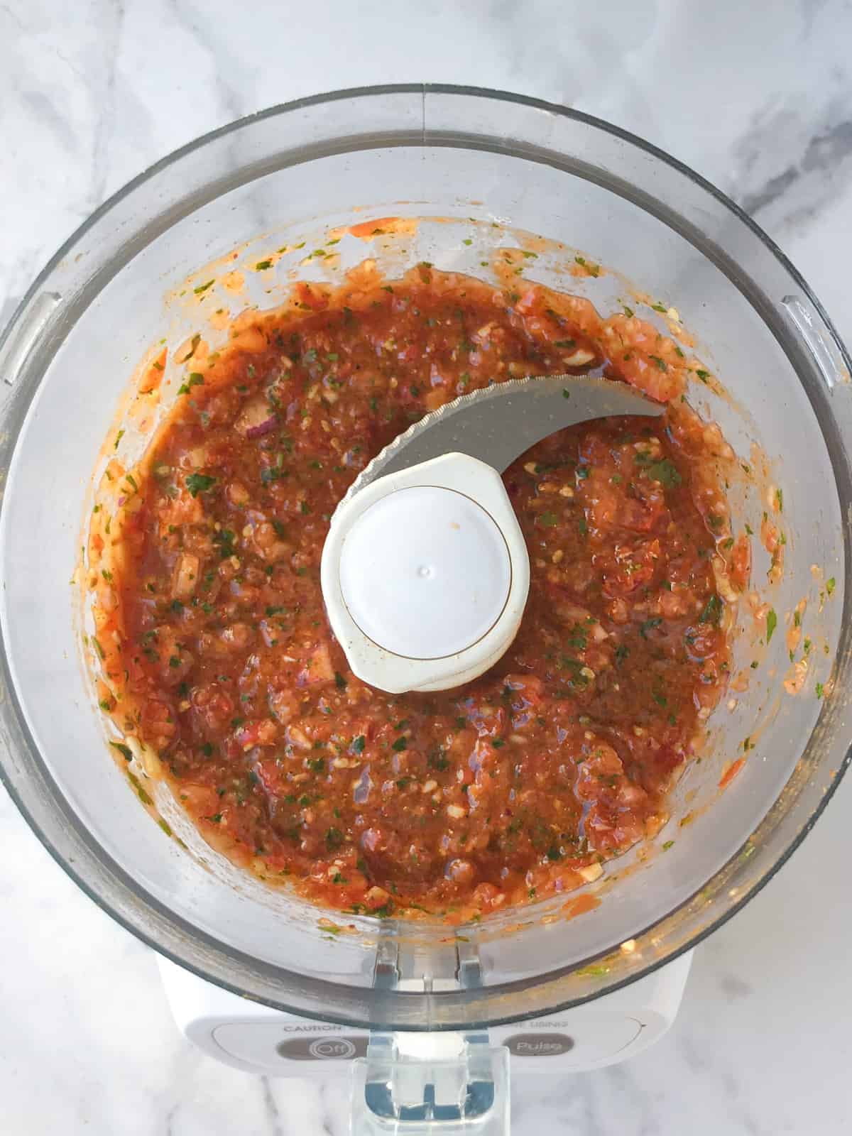 Blended tomato chutney in food processor bowl.