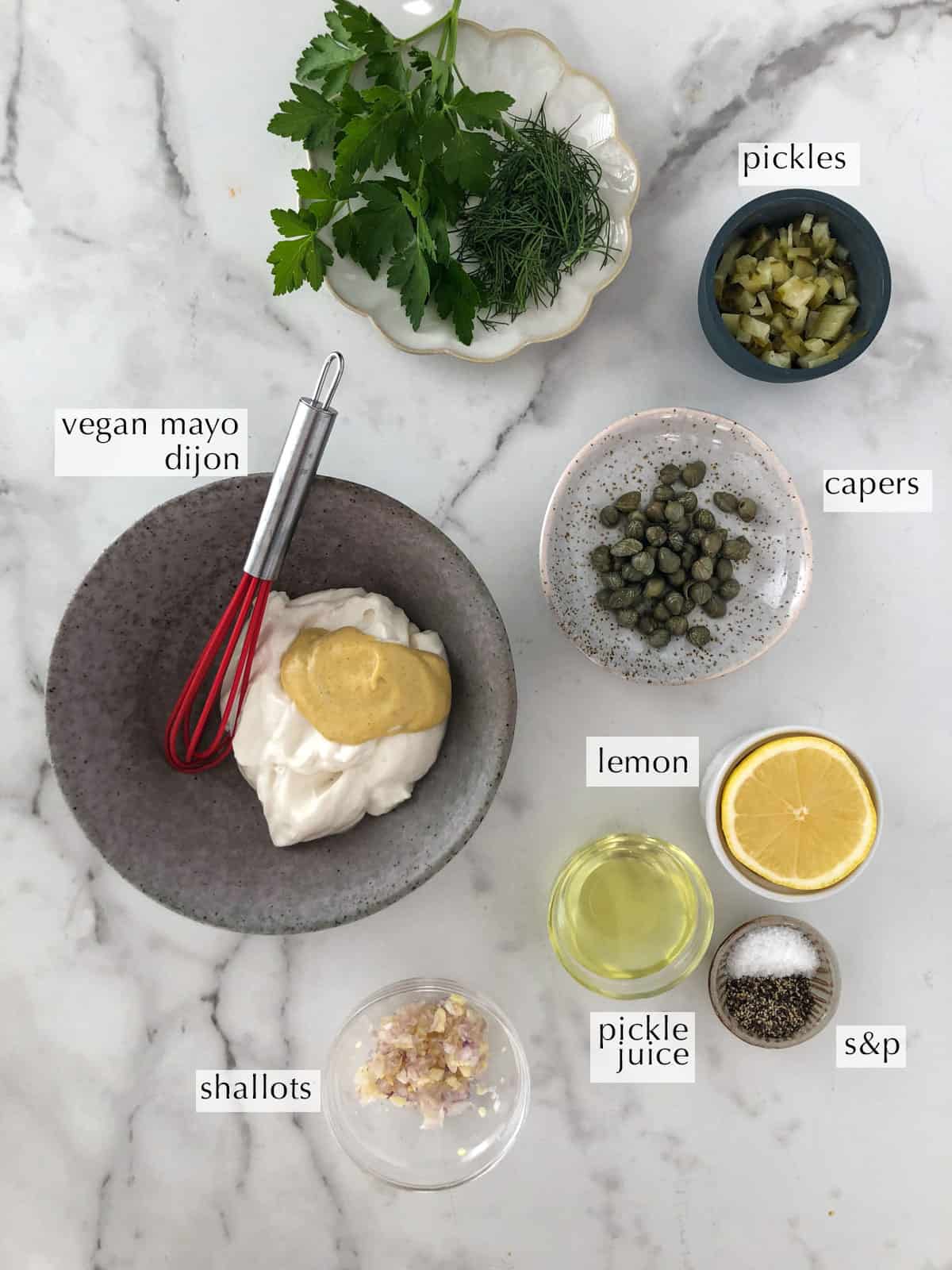 Bowls of ingredients for vegan tartar sauce like vegan mayo, mustard and pickles.