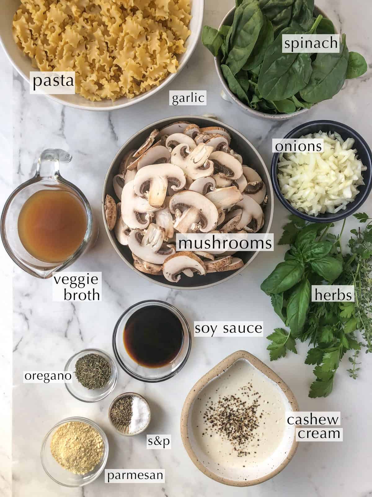 Ingredient for mushroom spinach pasta in small dishes on a counter top.