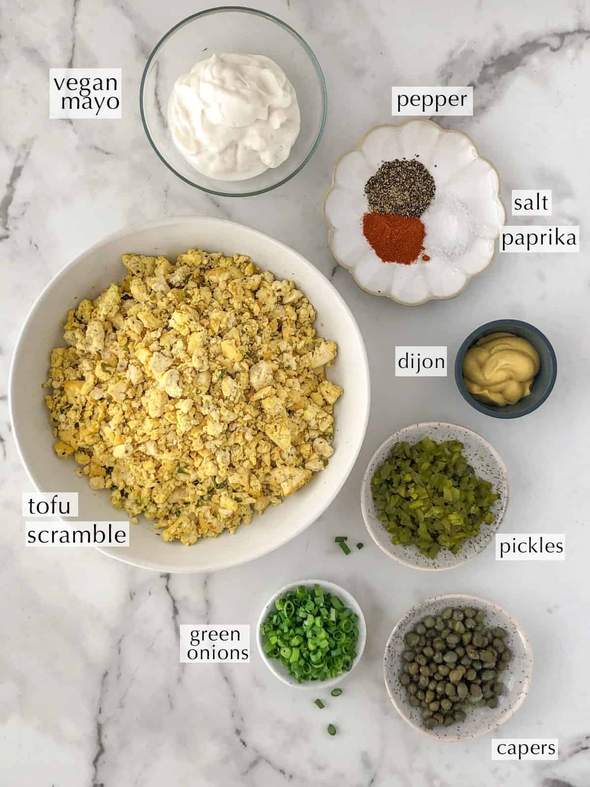 Ingredients for tofu egg salad sandwich in bowls on a work surface.