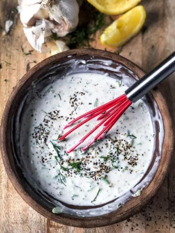 Tzatziki sauce whisked in a bowl.