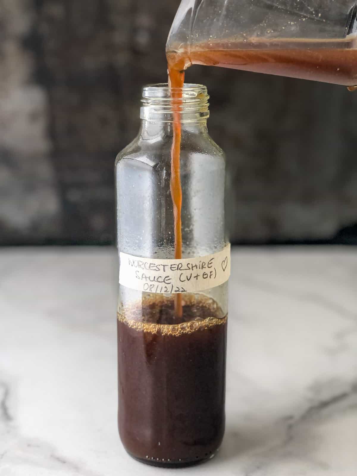 Worcestershire sauce being poured into a bottle.
