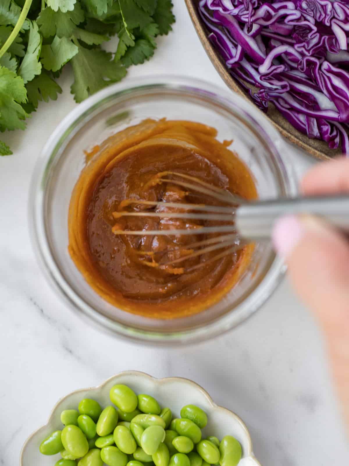Hoisin peanut sauce and a whisk in a jar.