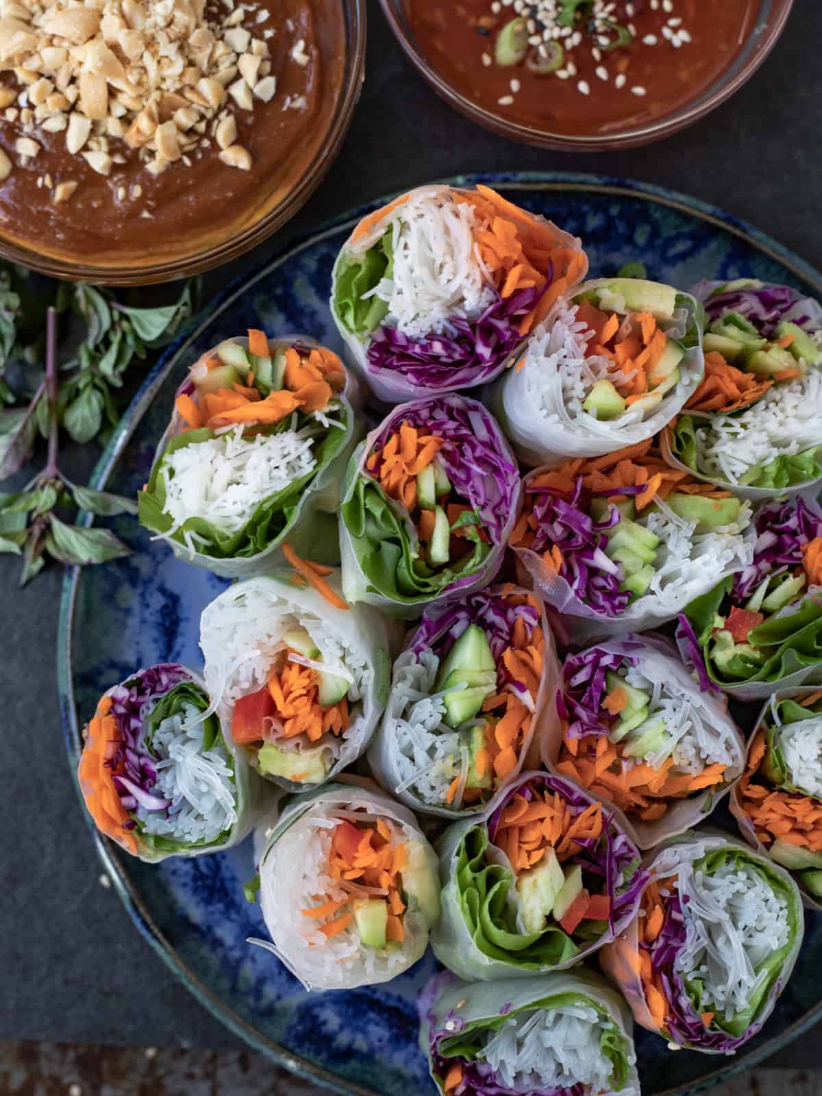 Plateful of vegetarian summer rolls with 2 bowls of dipping sauce.