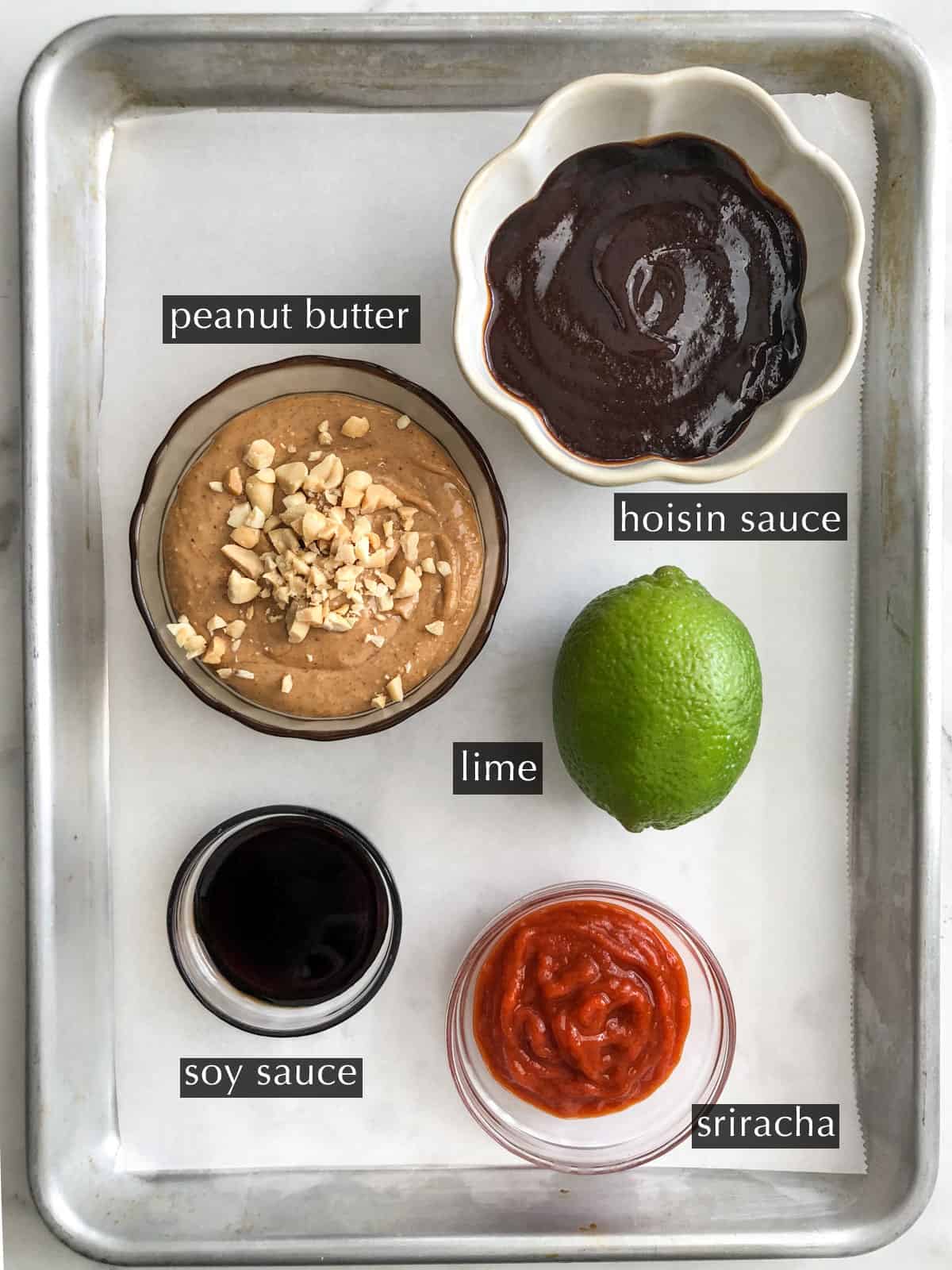 Tray with bowls of ingredients for hoisin peanut sauce.