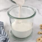 Dairy free heavy cream substitute made from cashews being poured into a jar.