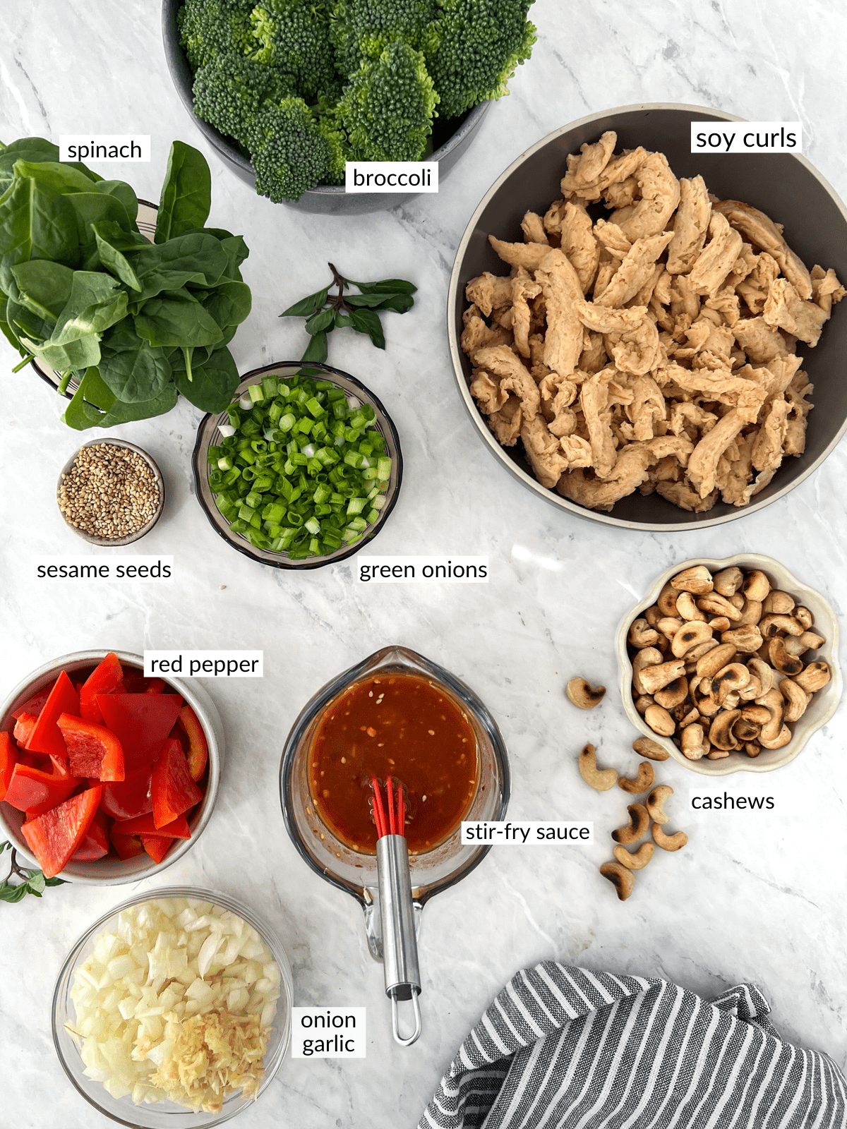 Ingredients for vegan chicken stir fry in bowls on a counter.