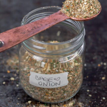 Jar of sage and onion seasoning with spoon on top.