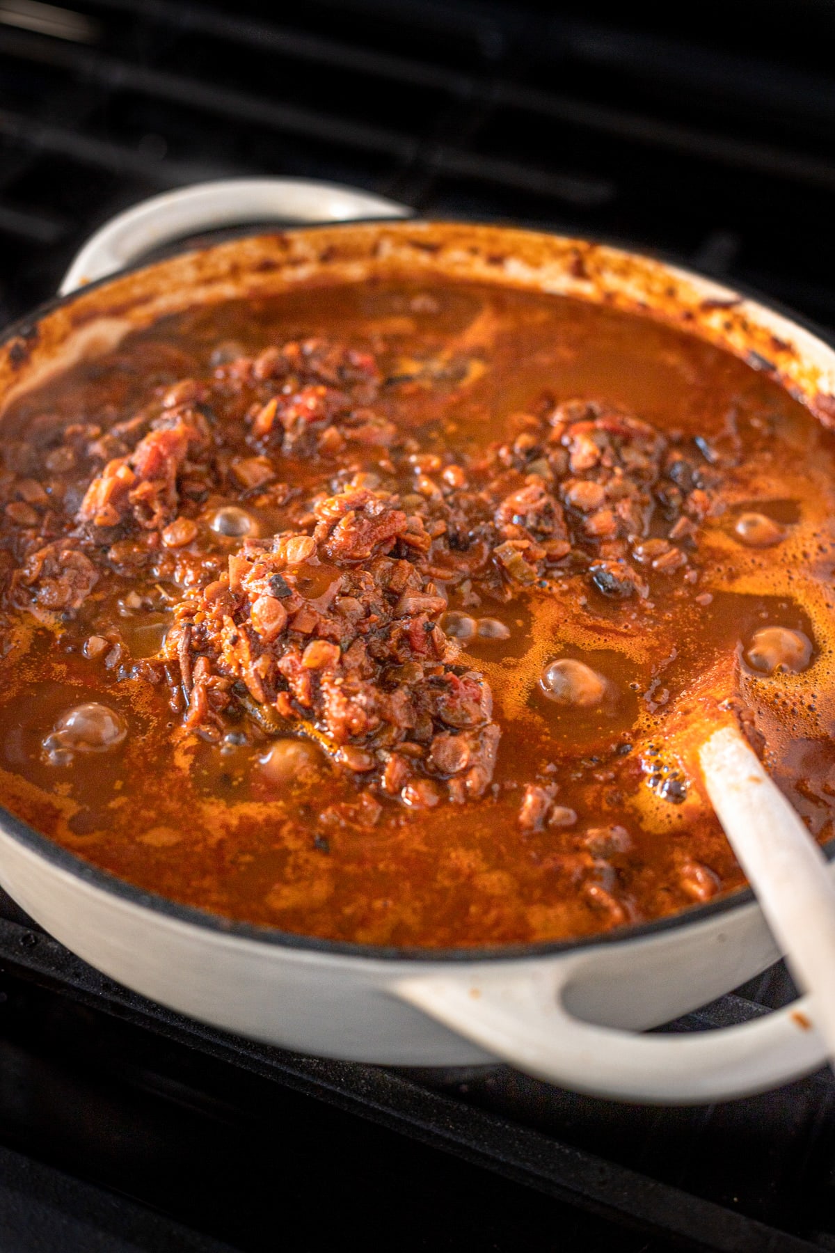 Vegetarian Lentil Bolognese simmering in a Dutch oven on the stove.