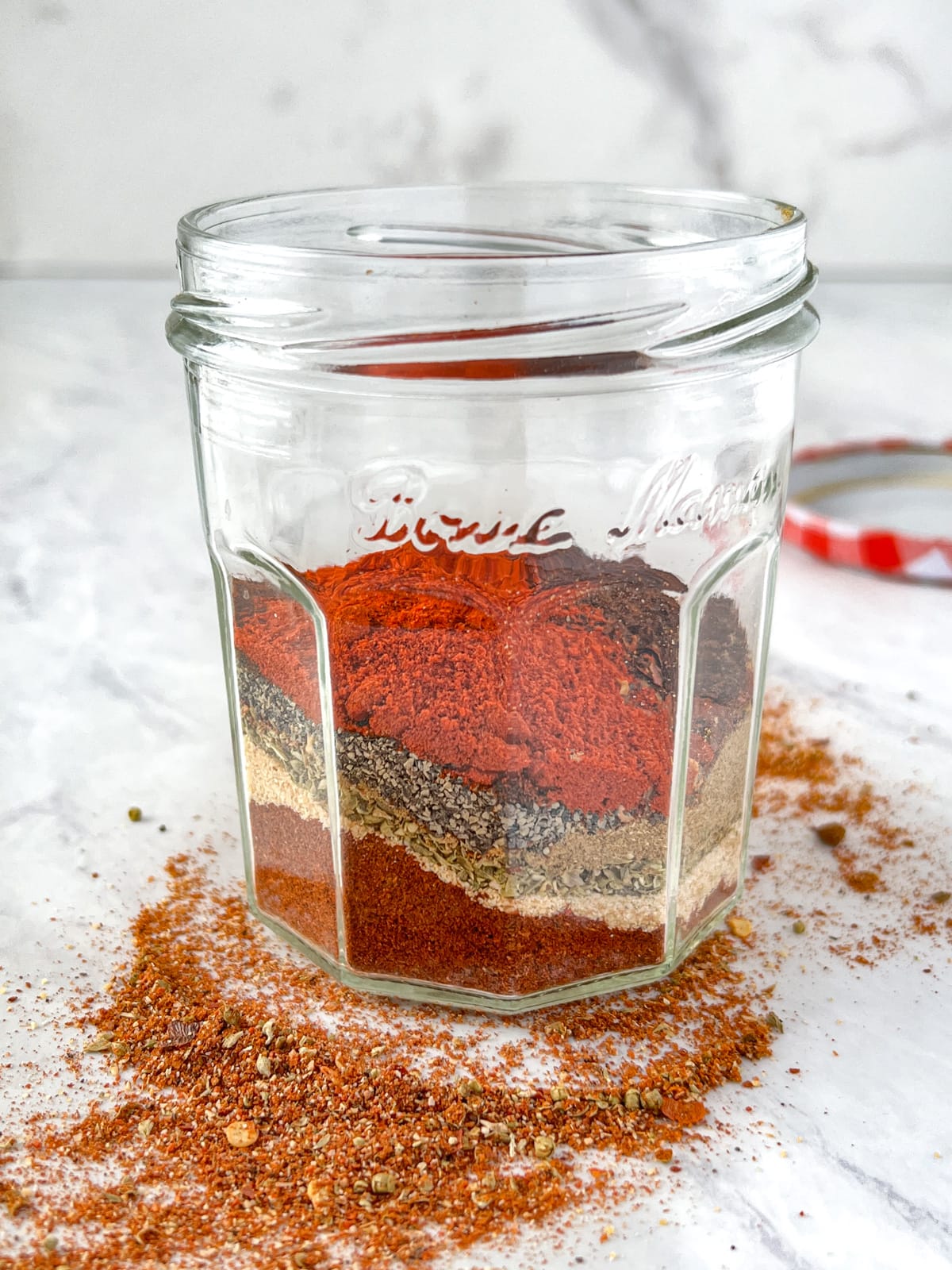 Jar with layers of spices to make taco seasoning.
