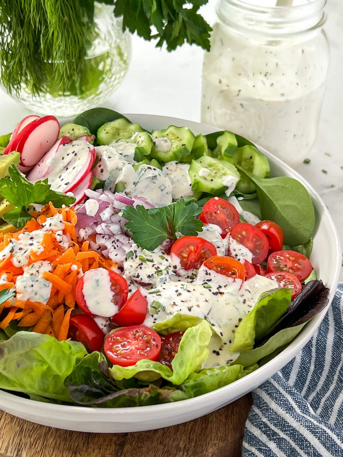 Bowl of garden salad with ranch dressing.