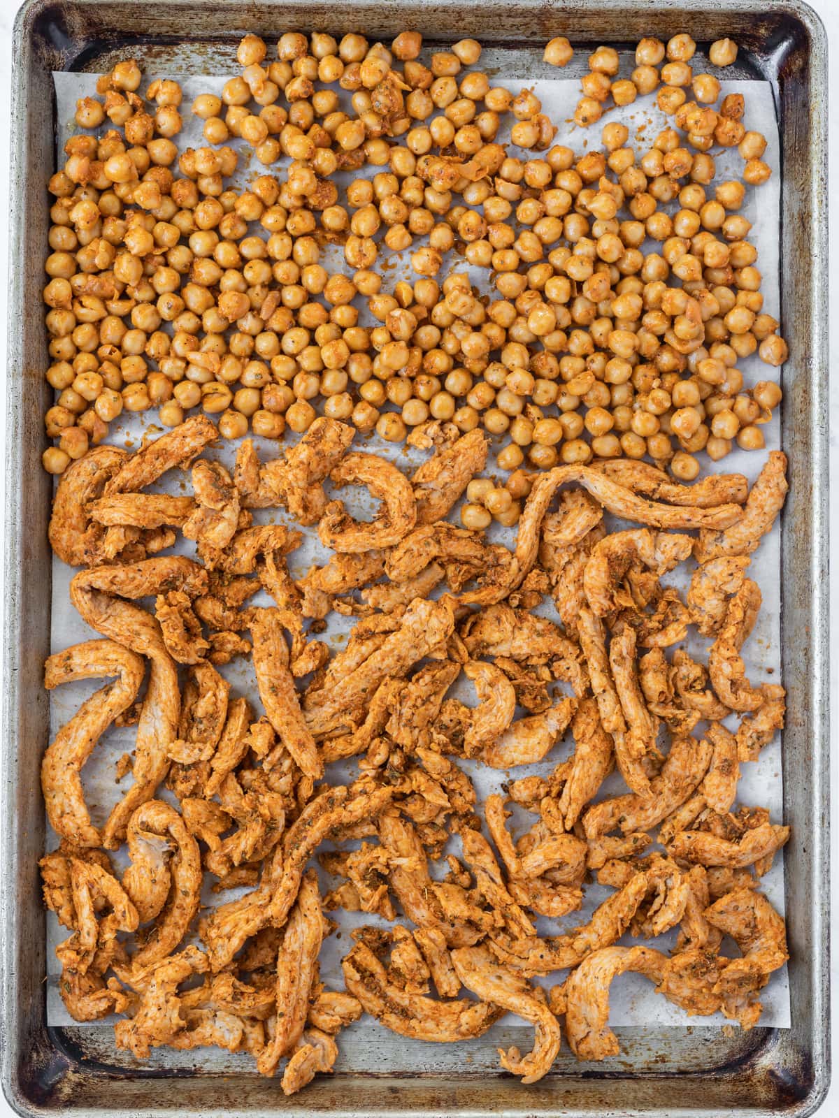 Spicy chickpeas and soy curls on a baking sheet before going into oven.