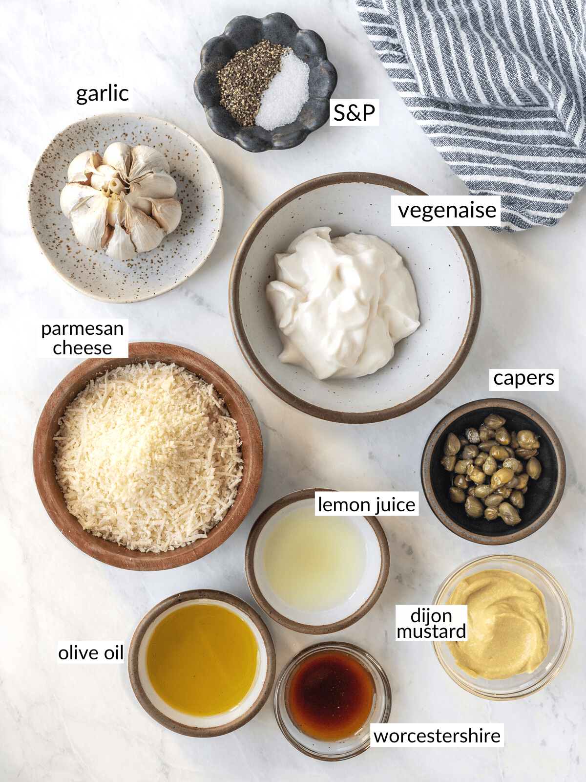 Ingredients for vegan caesar dressing set out in individual bowls.