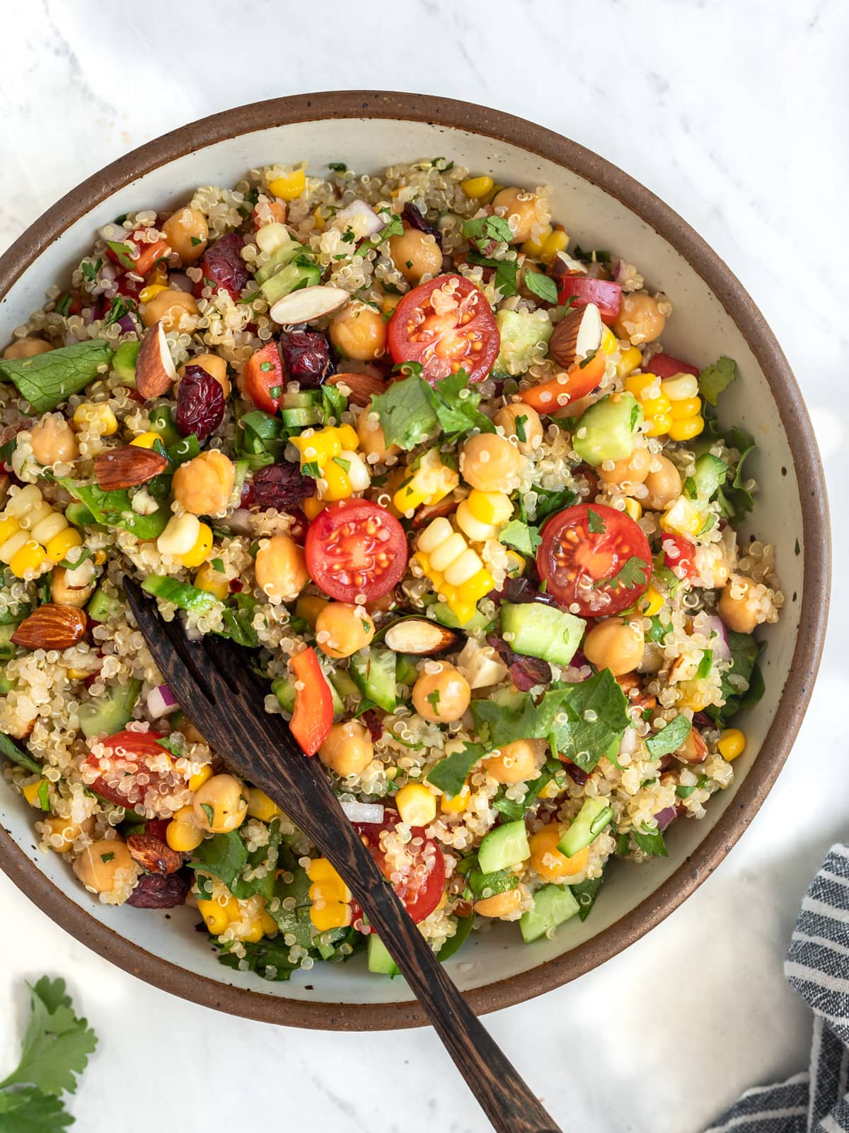 Bowl of quinoa salad packed with veggies like corn and tomatoes.