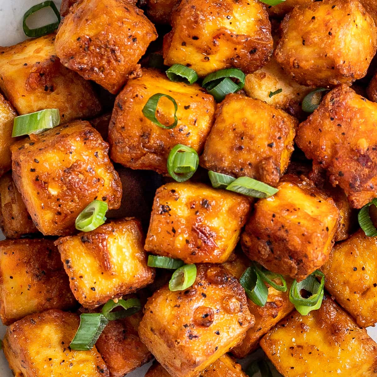 Crispy air fried tofu covered with sliced green onions.