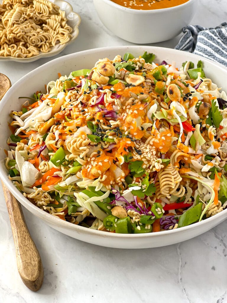 Bowlful of Asian chopped salad topped with ramen noodles and a dairy-free Asian dressing.