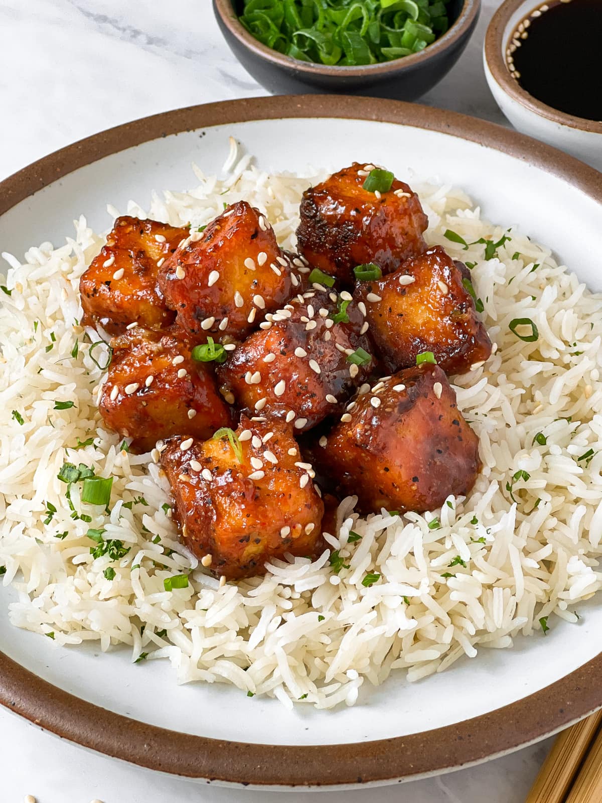Crispy pan fried tofu in sesame ginger sauce served on a bed of rice.