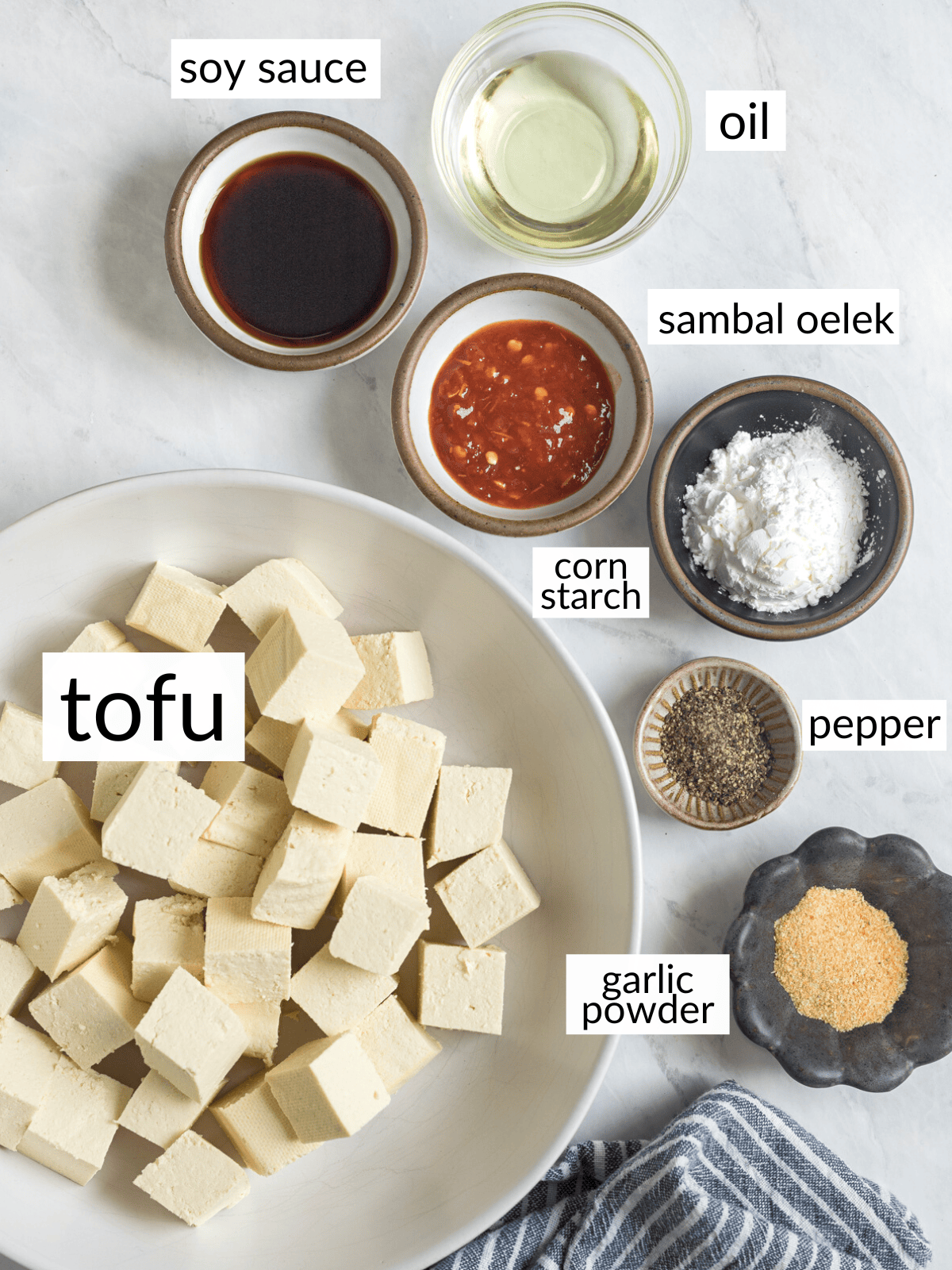 Ingredients for pan-fried tofu in individual bowls on a white counter top.