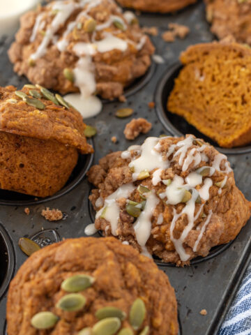 Pan of pumpkin muffins with frosting drizzling
