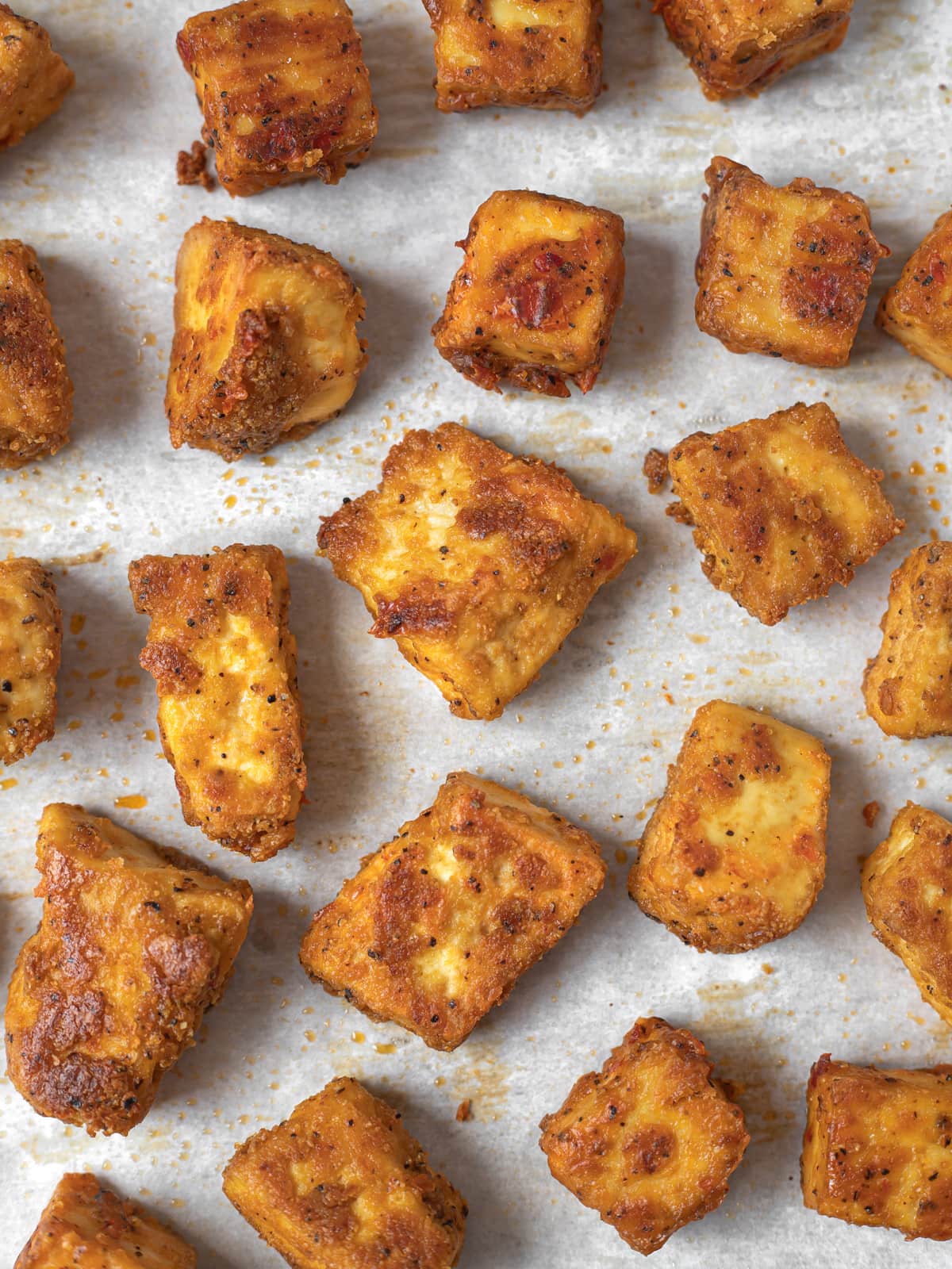 Crispy, golden brown baked tofu nuggets on a baking sheet.