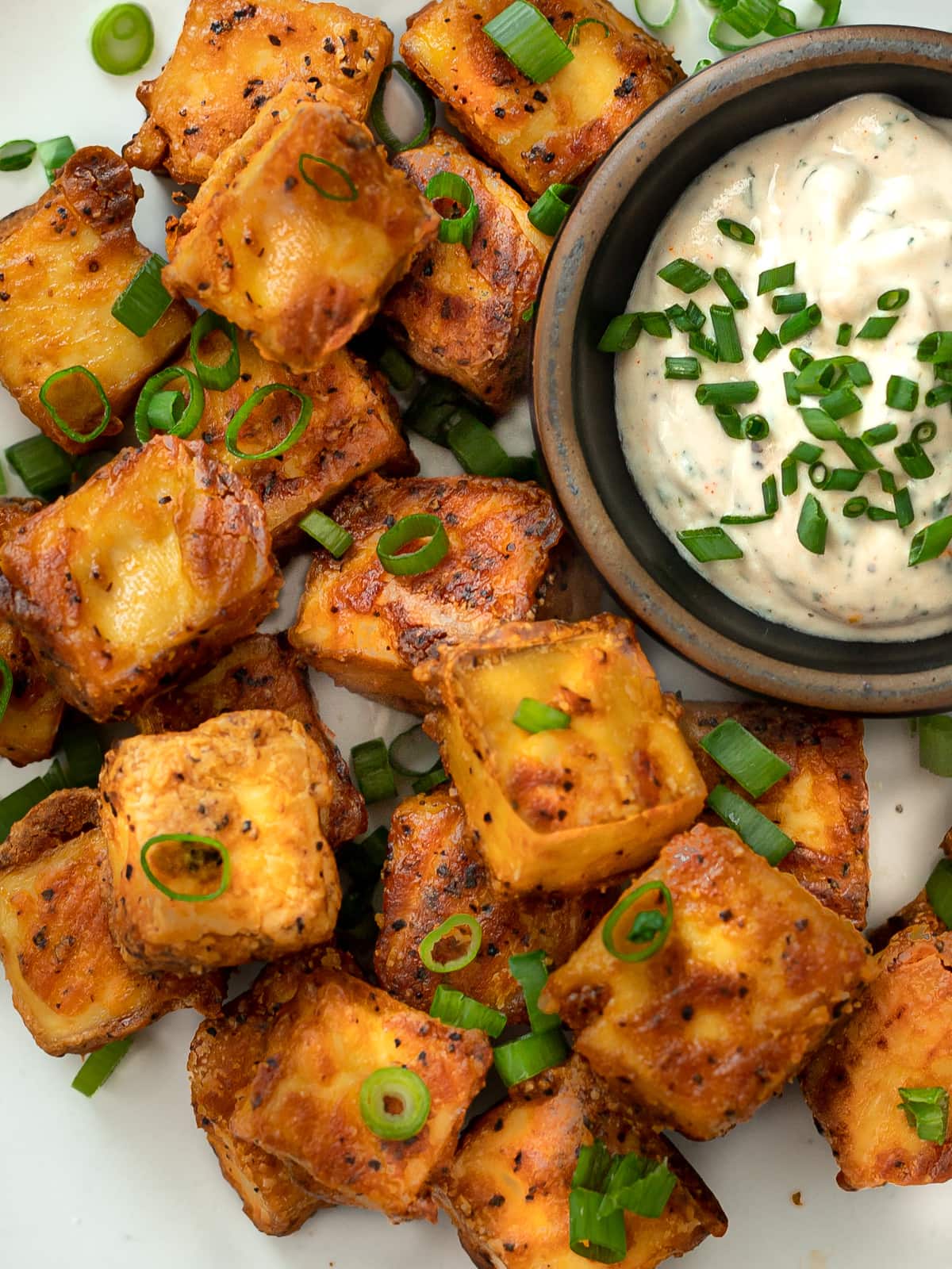 Plateful of crispy baked tofu cubes and bowlful of ranch dressing.