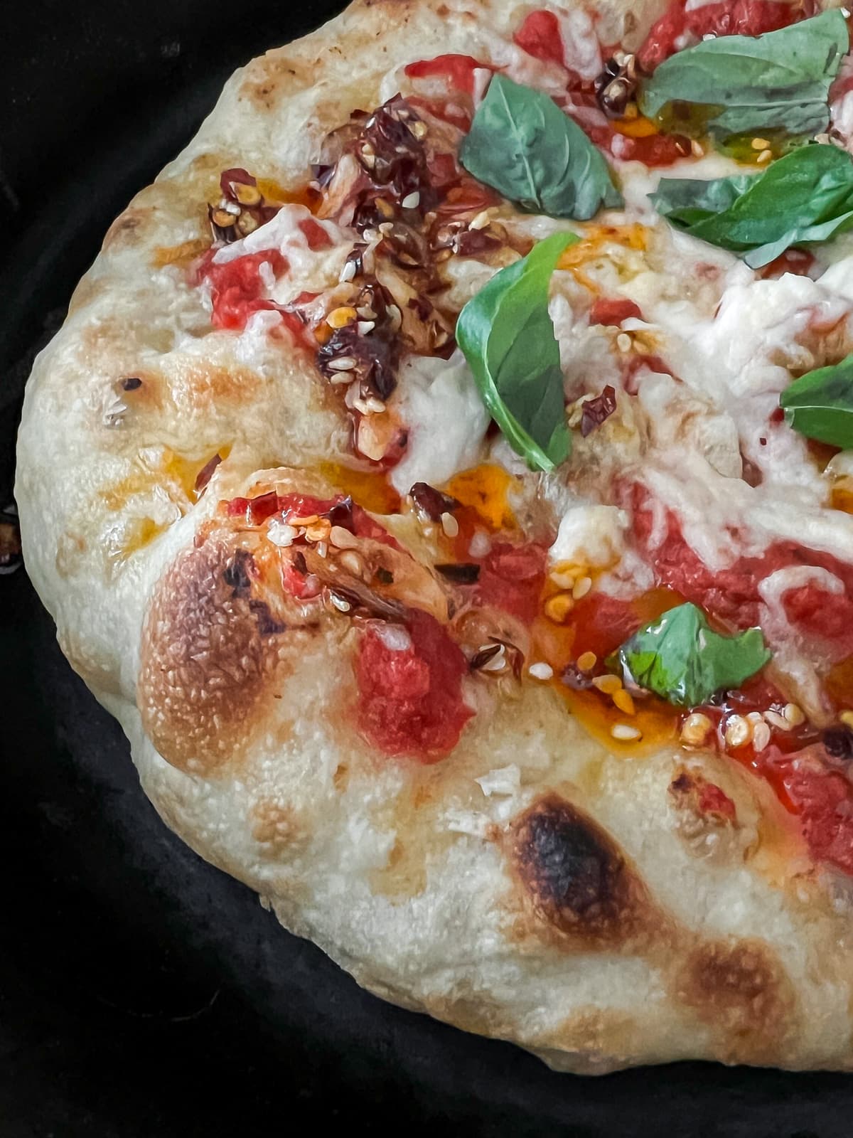 Homemade pizza crust loaded with pizza sauce, vegan cheese and toppings.