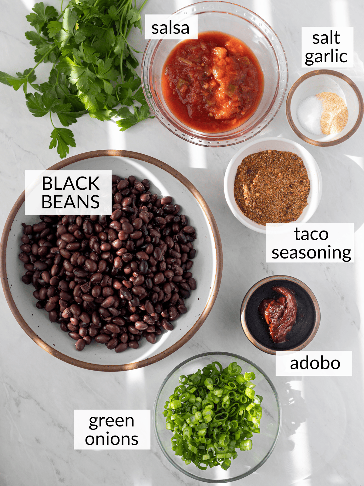 Ingredients for black bean tacos in individual bowls.