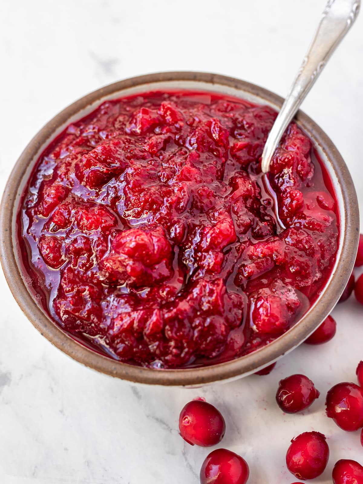 Bowlful of cranberry sauce with spoon.