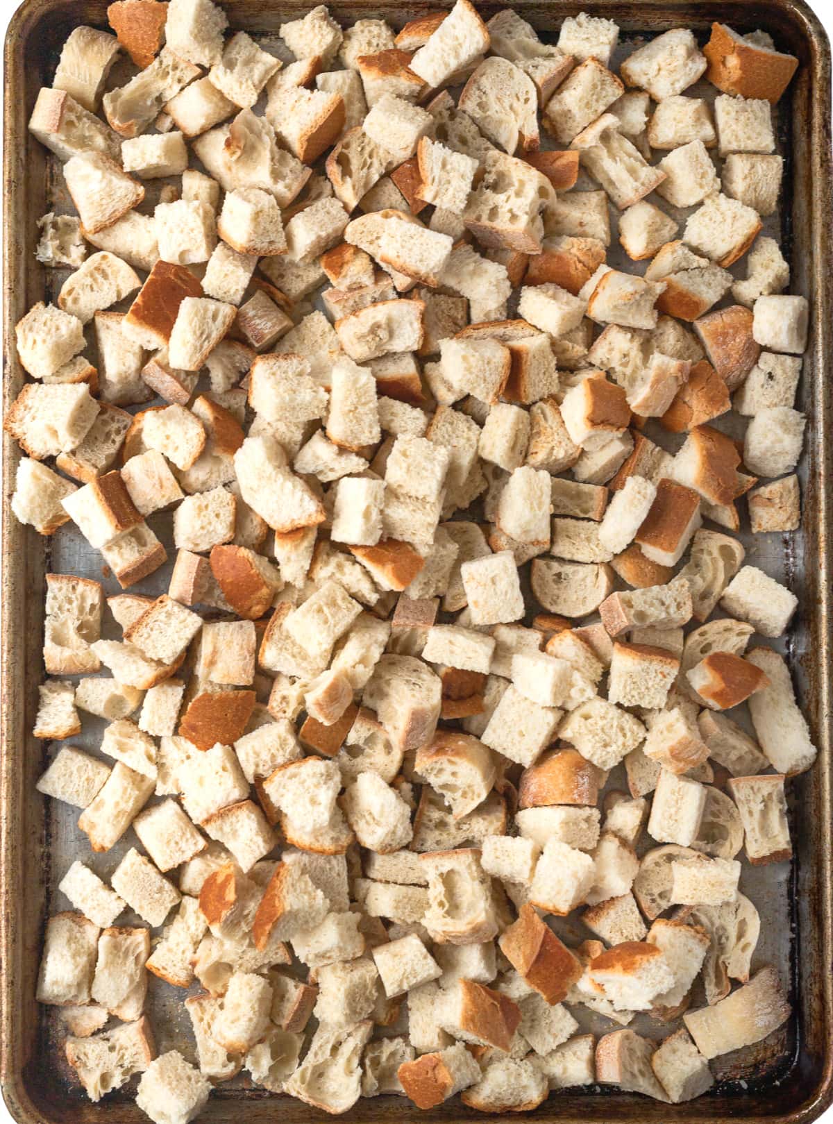 Bread cubes on a large baking sheet.
