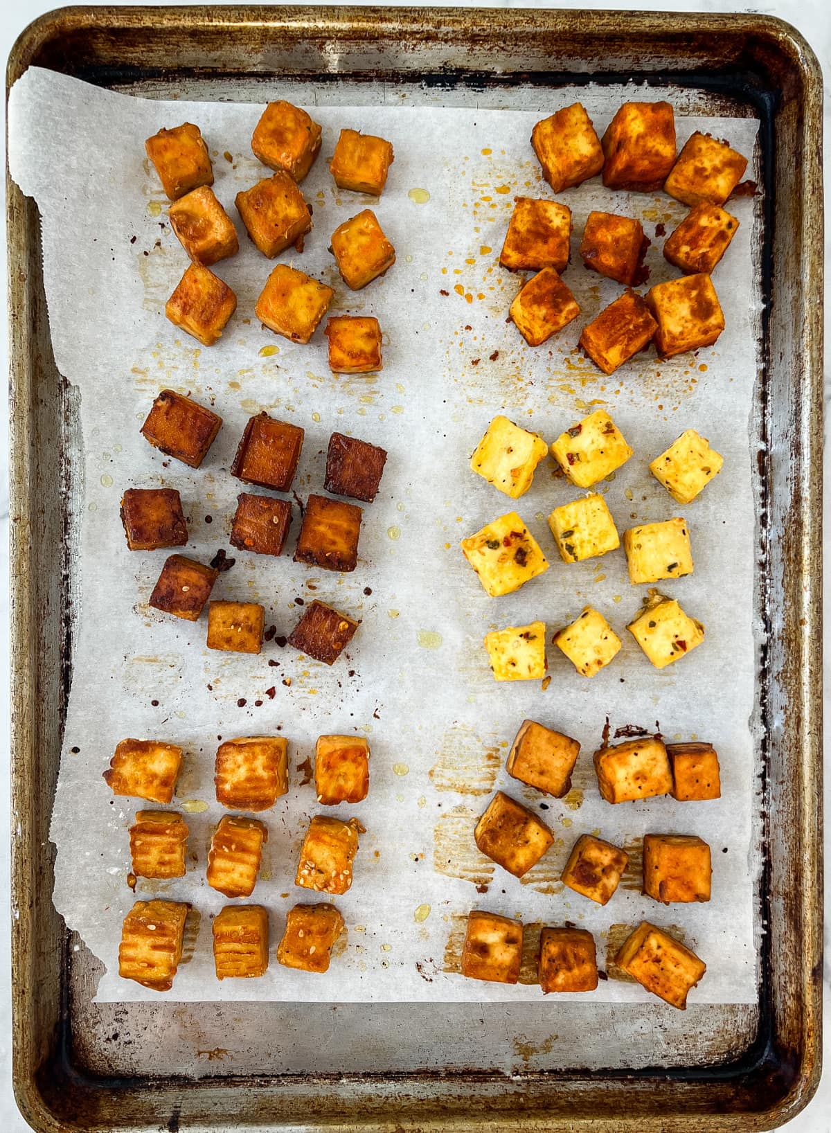 Marinated tofu cubes on a baking sheet.