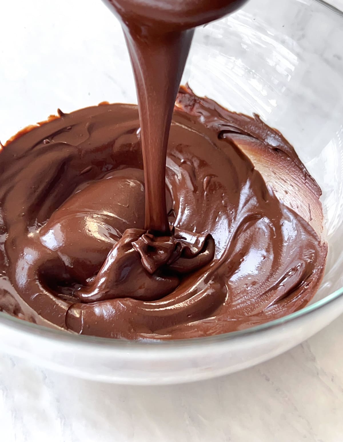 Bowl full of glossy melted dairy free chocolate.