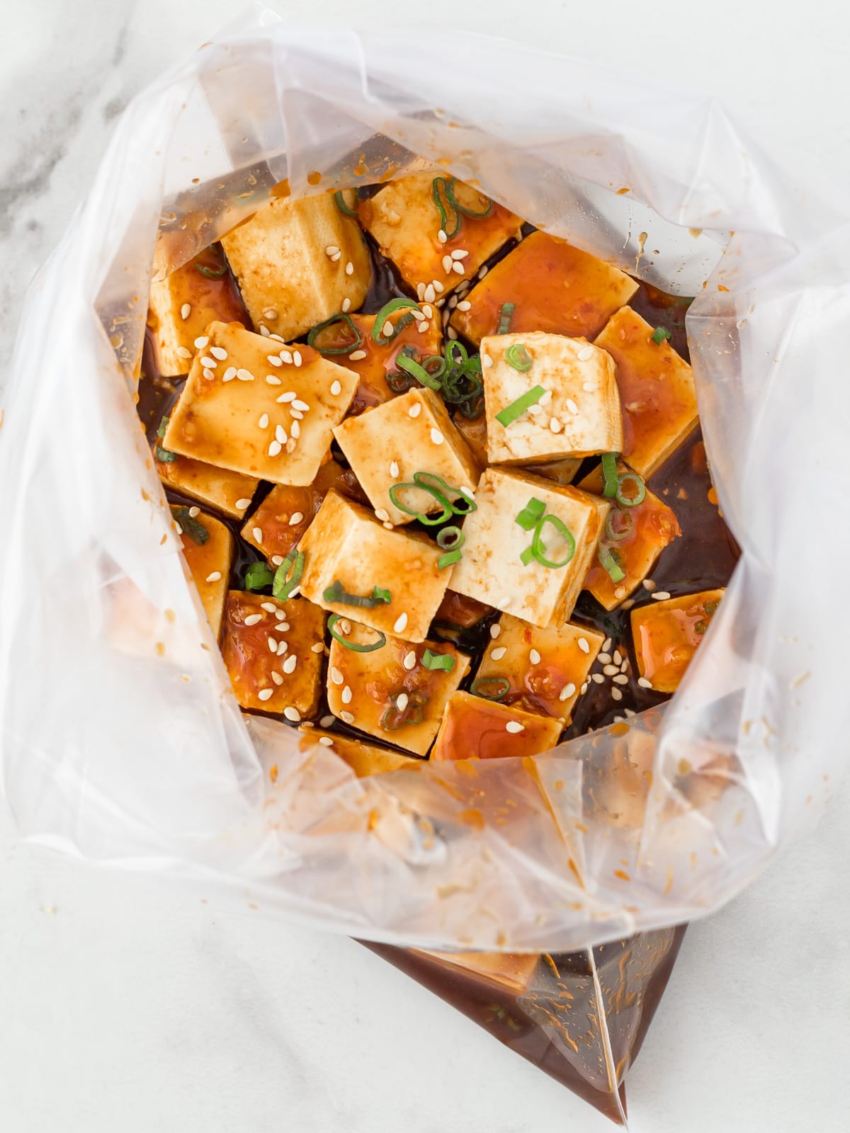 Tofu cubes in a bag of marinade.