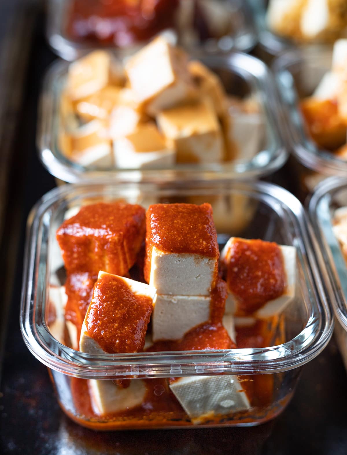 Pressed tofu cubes soaking up flavorful marinade.